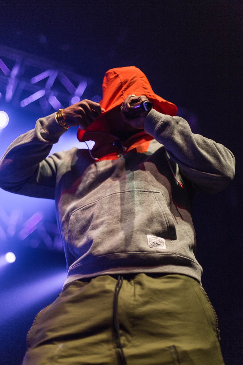 Ja Rule performing on stage with his hood over his head.